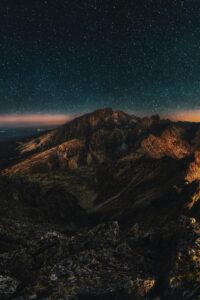 Stunning starry night sky over rugged mountains, perfect for nature lovers.
