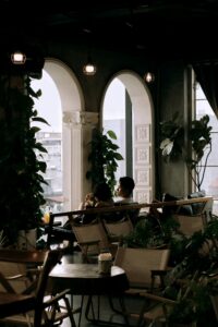 Charming indoor cafe setting with elegant arches and lush greenery.